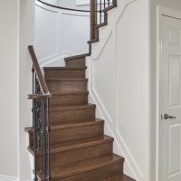 Dark-hardwood-staircase-with-light-flooring-and-white-decotative-walls-min