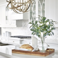 White-kitchen-with-quatrz-countertops-and-circular-pendant.-white-custom-cabinetry-and-breakfast-with-floral-arrangement-min