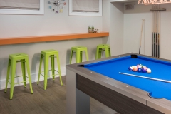 Basement-pool-table-with-green-and-orange-bar-seating
