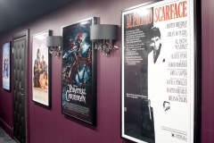 Basement-theatre-with-movie-posters-and-light-sconces-on-purple-wall